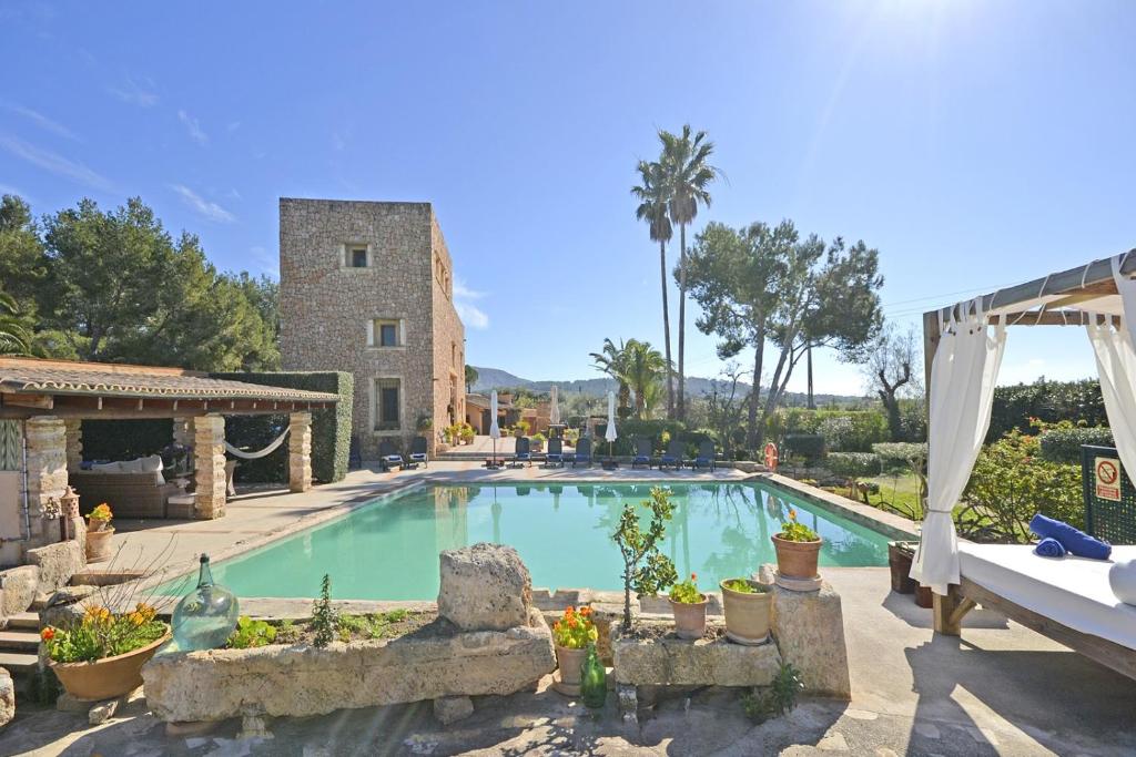 a swimming pool in front of a house at Villa Torreon in Alcudia