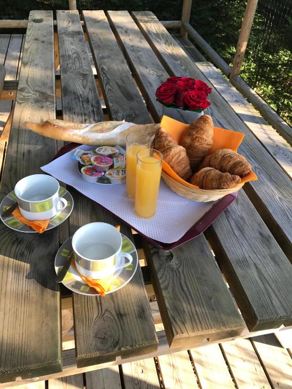 - une table avec un panier de pain et des tasses de jus d&#39;orange dans l&#39;établissement Camping Les Chèvrefeuilles, à Royan