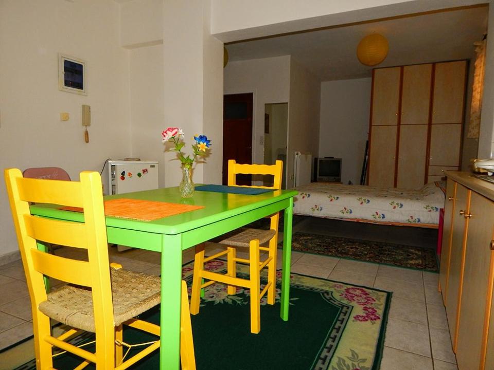 a green table and chairs in a kitchen with a room at Small studio near the center of Tripoli in Tripoli