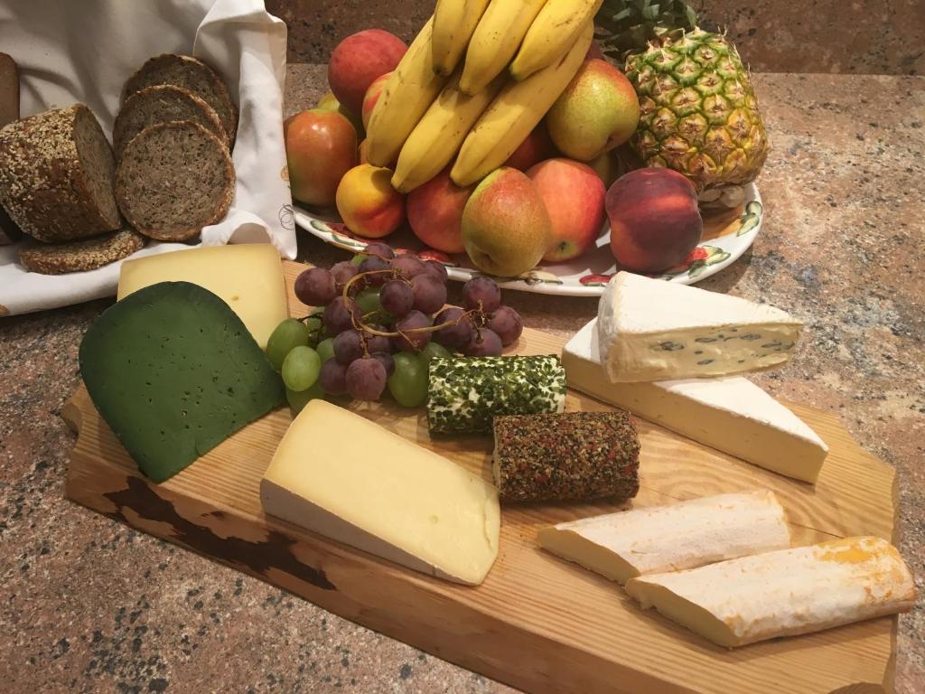 a cutting board with different types of cheese and fruit at Das kleine, feine SONNWEND in Alpbach