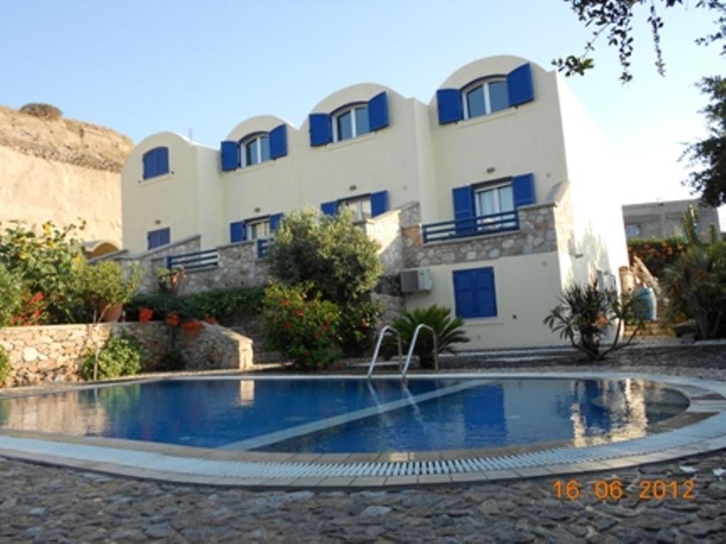 a building with a swimming pool in front of a building at Sea Bliss Villas in Karterados