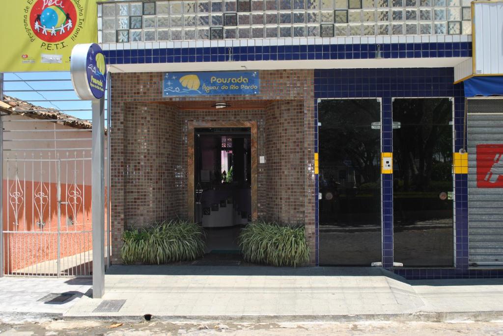 a brick building with a door with plants in front at Pousada Aguas do Rio Pardo in Cândido Sales