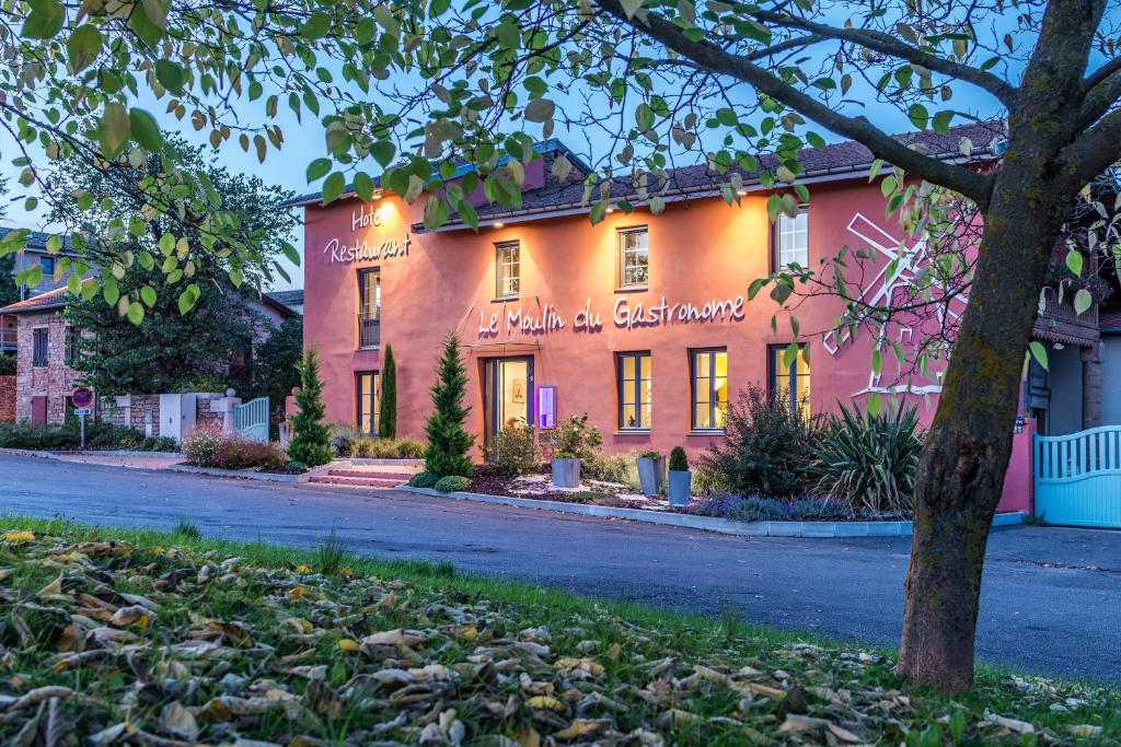 un edificio rosa con un cartel. en Le Moulin du Gastronome, en Charnay-lès-Mâcon