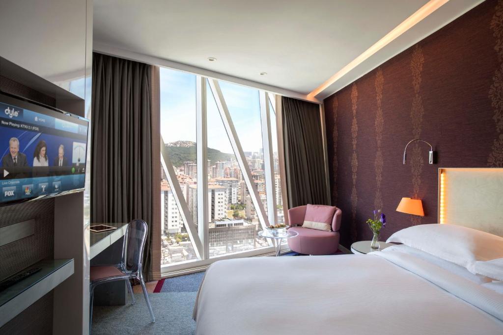 イスタンブールにあるBurgu Arjaan by Rotana Istanbul Asiaのベッドと大きな窓が備わるホテルルームです。