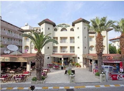 a large building with palm trees in front of it at Miray Hotel in Marmaris