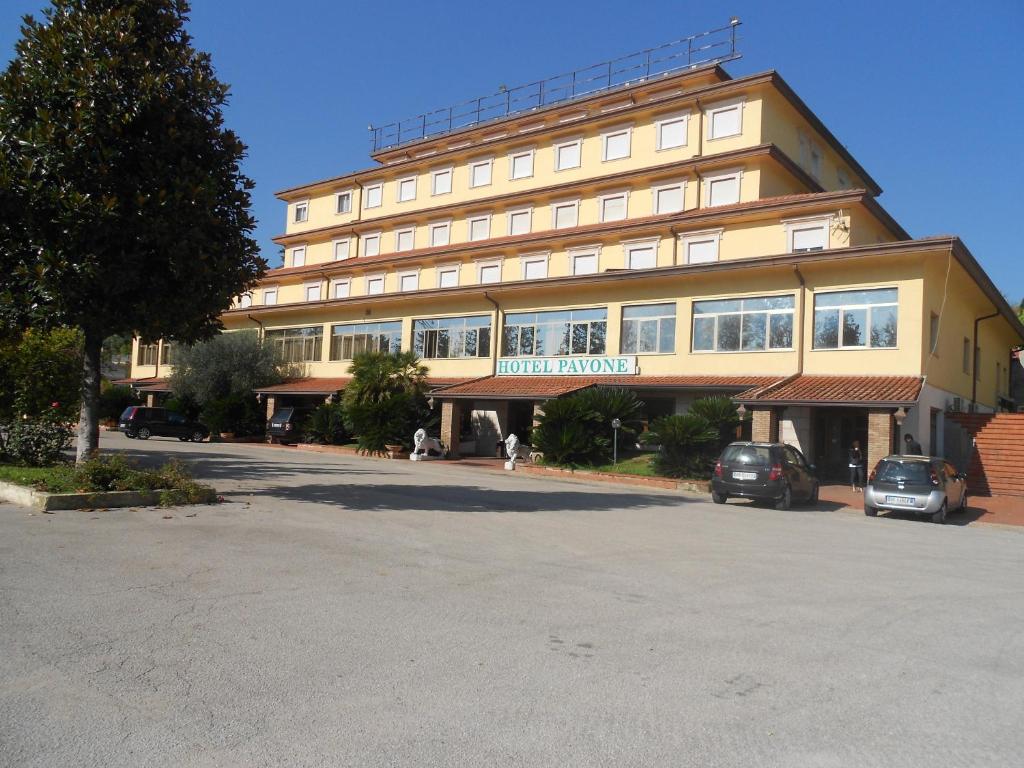 un gran edificio con coches estacionados frente a él en Grand Hotel Pavone, en Cassino