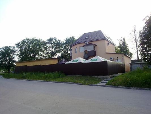 ein Haus mit einem Zaun vor einem Haus in der Unterkunft Dlya Vseh Motel in Kamjanez-Podilskyj