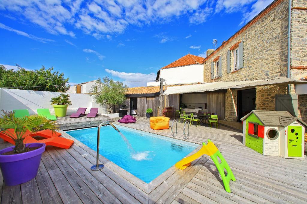 a backyard with a swimming pool and a wooden deck at La Chaize - Villa, Suites & Spa in Noirmoutier-en-l'lle