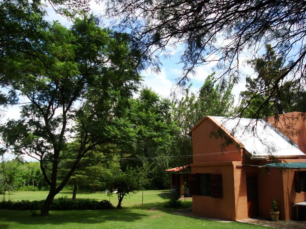 een klein rood gebouw met bomen op de achtergrond bij El Limon in San Marcos Sierras