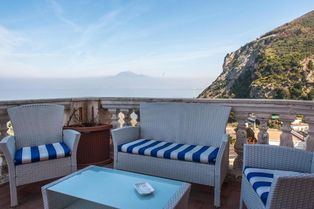 a balcony with chairs and a table and the ocean at Villa Margi in Vico Equense