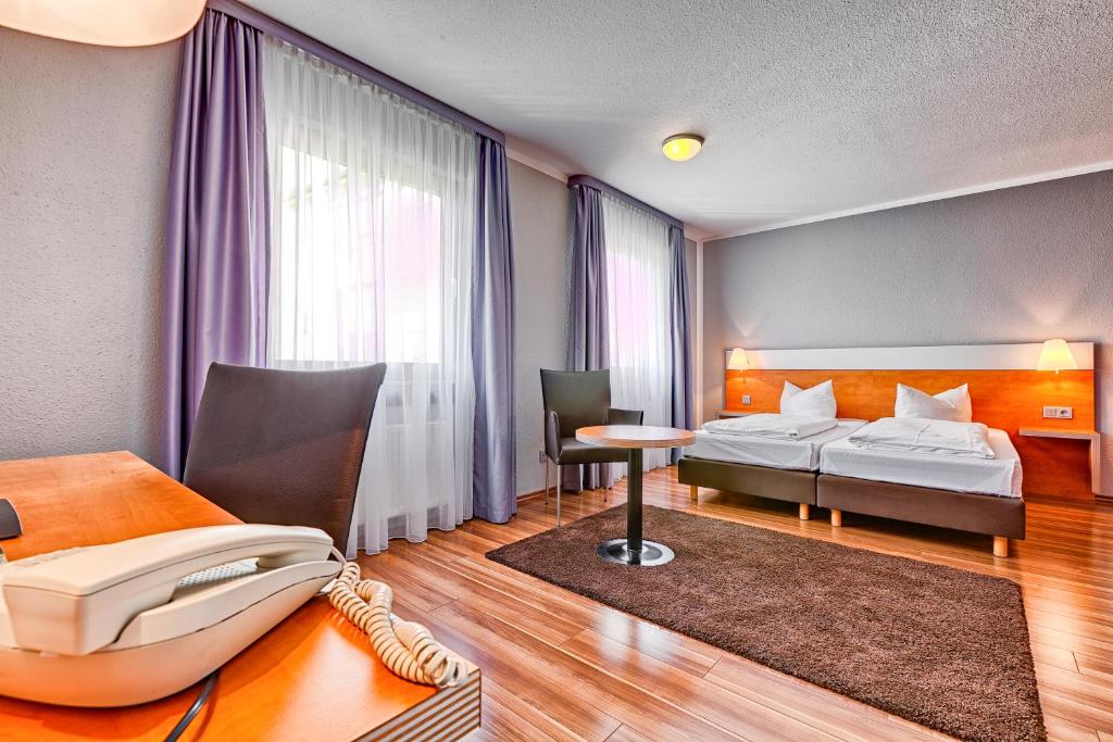Postel nebo postele na pokoji v ubytování attimo Hotel Stuttgart***S