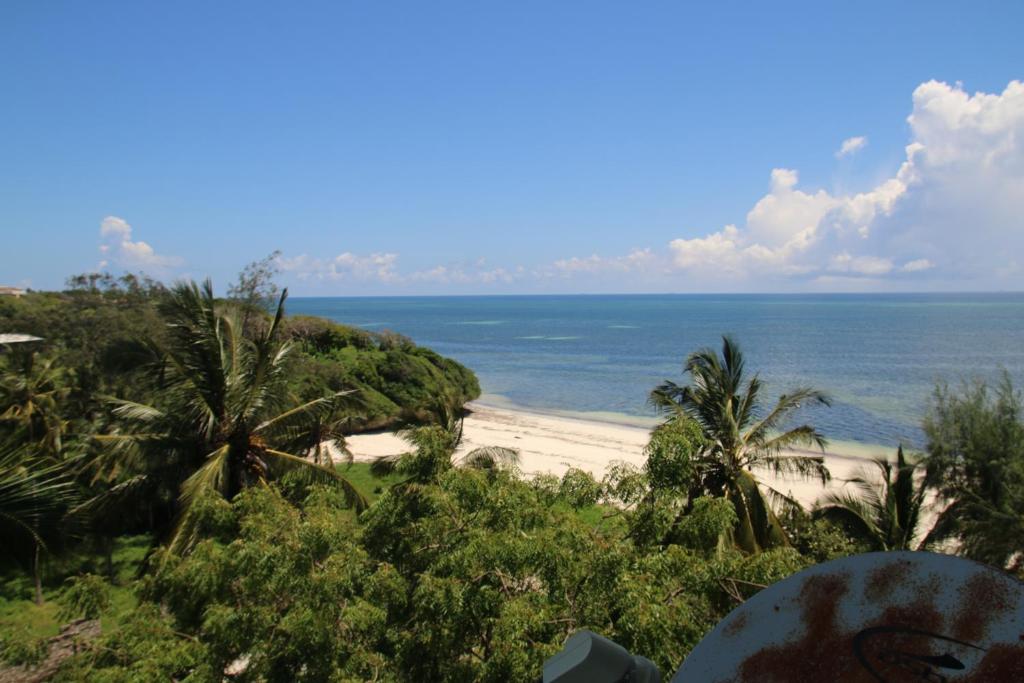 vistas a una playa con palmeras y al océano en Modern Beach Front Studio Apartment - B44 en Mombasa