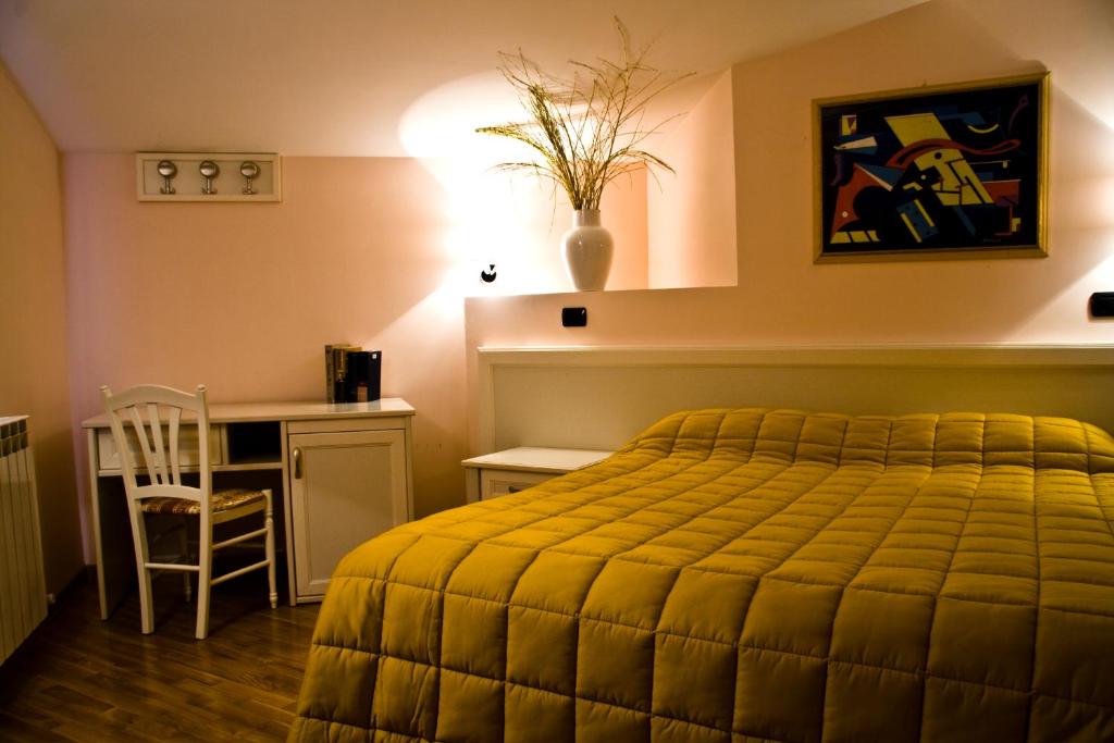 a bedroom with a bed and a desk and a chair at Albergo Ristorante Siro in Torgiano