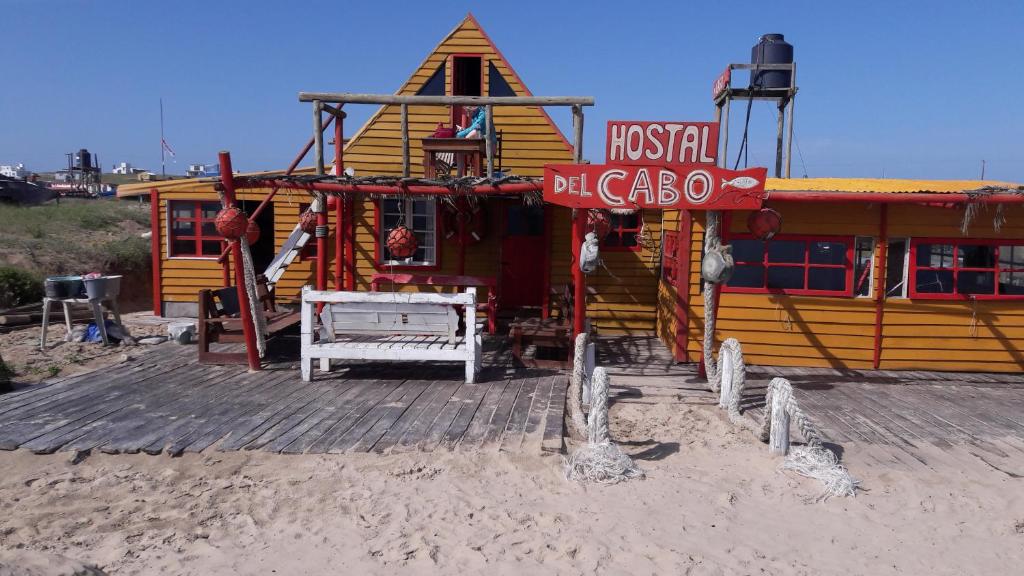 - un restaurant sur la plage avec un panneau devant dans l'établissement Hostal del Cabo, à Cabo Polonio