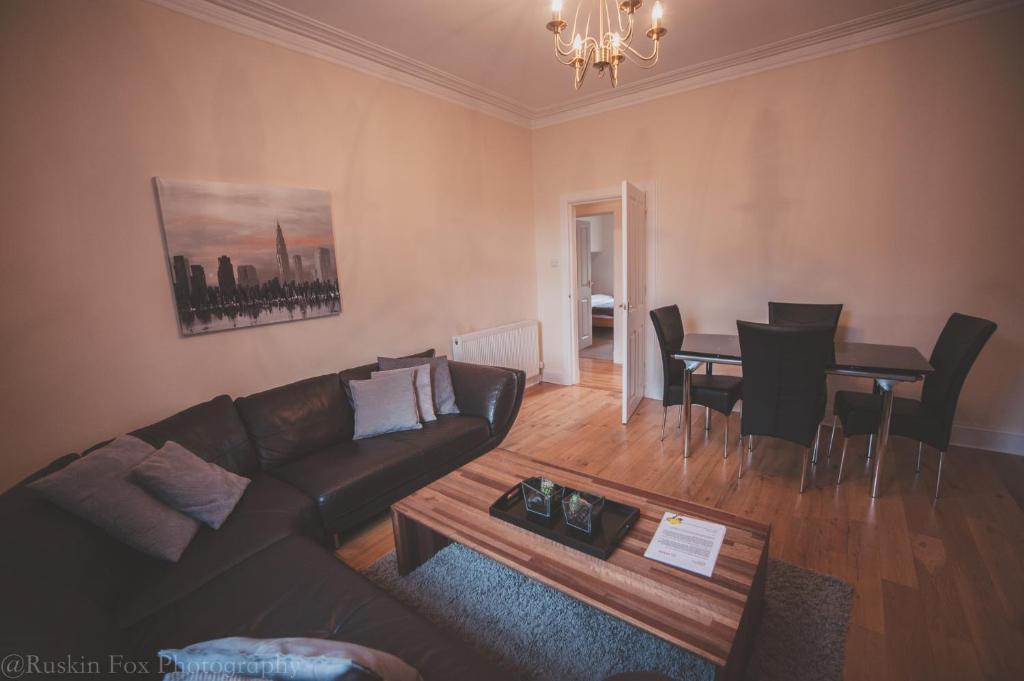a living room with a couch and a table at Stylish and Spacious two bed in Aberdeen's West End in Aberdeen