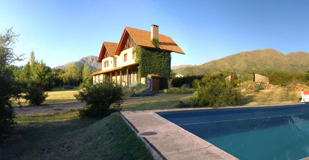 una casa con piscina delante de una casa en Cabañas Atardeceres, en Capilla del Monte