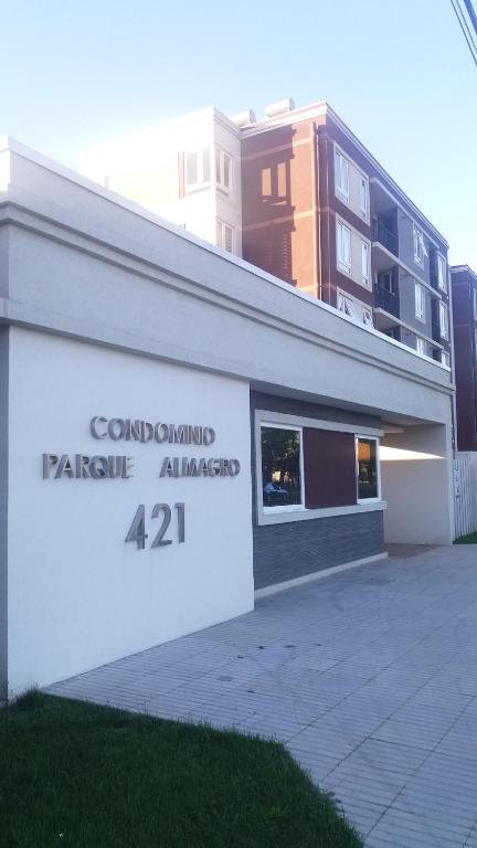 un edificio con un cartel en el costado en Condominio Parque Almagro, en Chillán