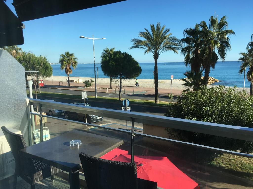 a table and chairs with a view of the beach at Tiercé Hotel in Cagnes-sur-Mer