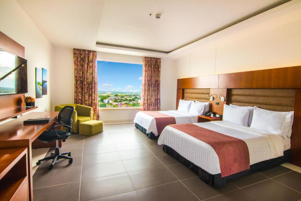 Postel nebo postele na pokoji v ubytování GHL Hotel Grand Villavicencio