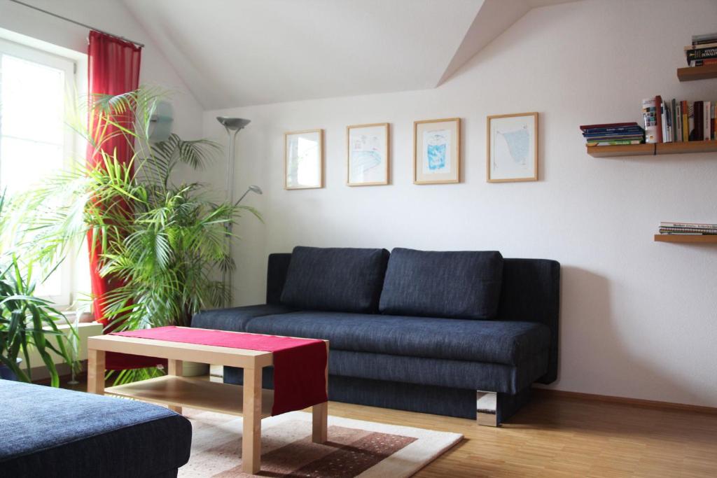 a living room with a blue couch and a table at Haus Köberle Ummendorf in Ummendorf-Biberach