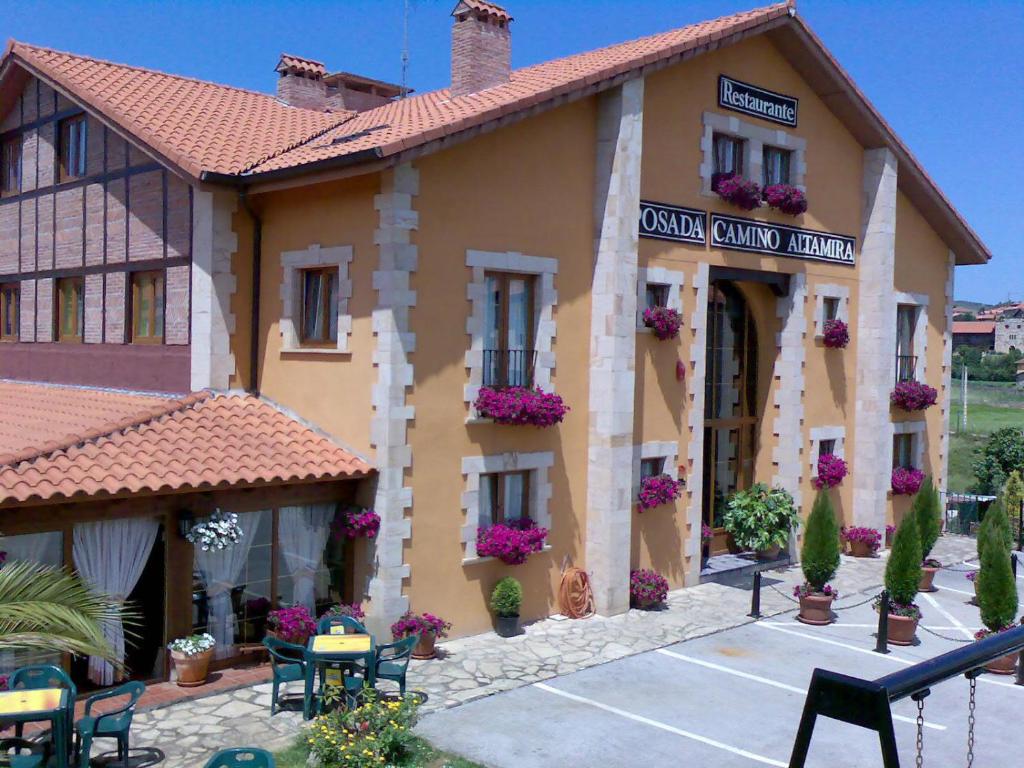 un edificio con dei fiori sulla parte anteriore di Posada Camino de Altamira a Santillana del Mar