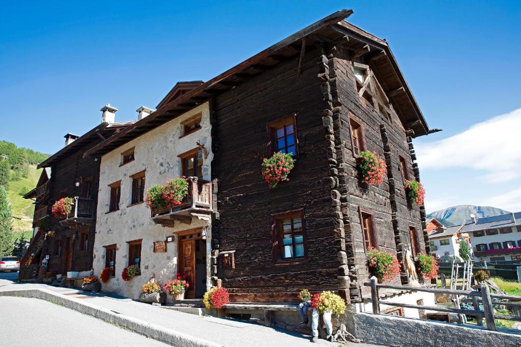 un edificio con macetas al costado. en Bait Vegl en Livigno