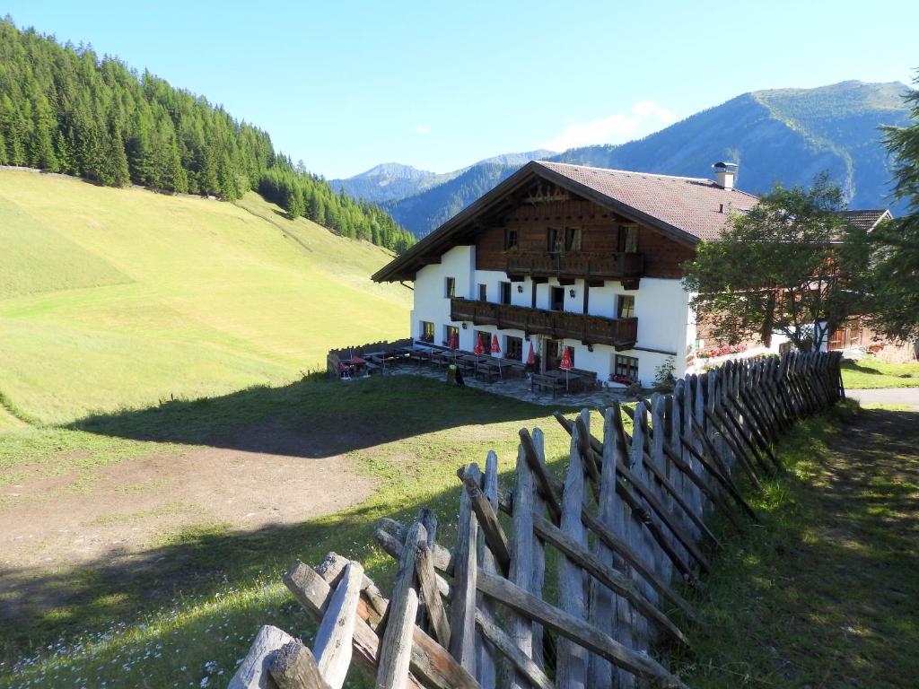 ein Holzzaun vor einem Haus in der Unterkunft Berggasthof Steckholzer in Sankt Jodok am Brenner