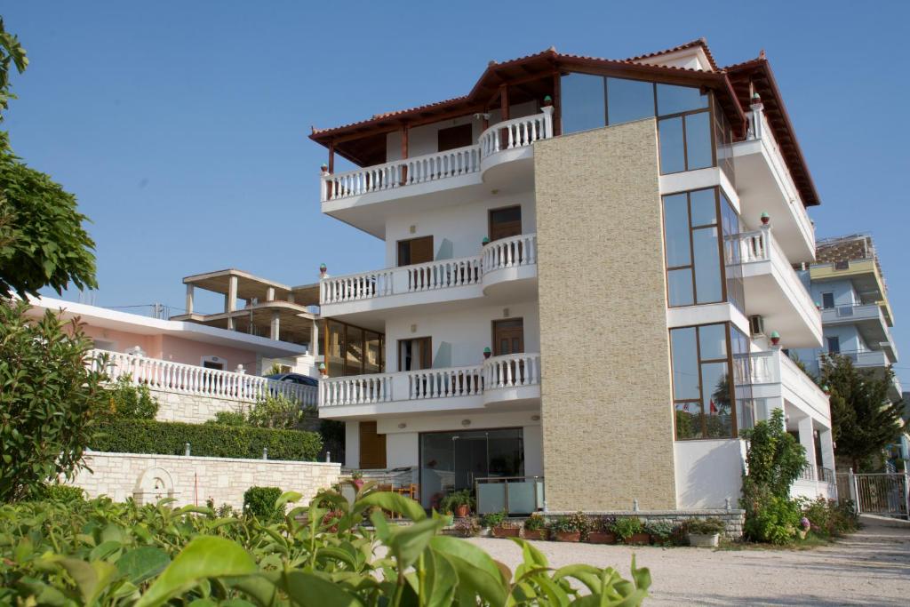 un edificio blanco con balcones en un lateral en Villa Ideal, en Ksamil