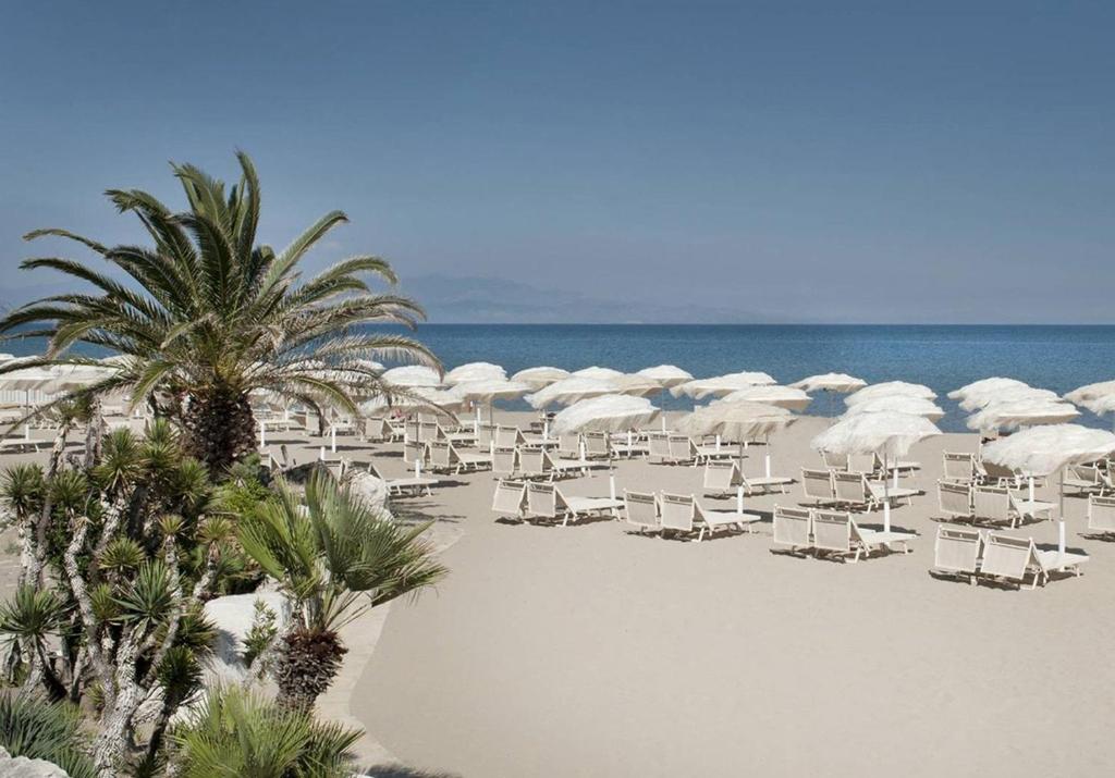 plaży z leżakami, parasolami i palmami w obiekcie B&B Volì Club w mieście Siderno Marina