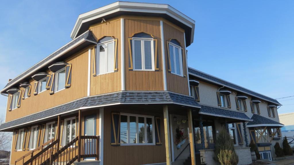 une maison avec un toit en gambrel dans l'établissement Auberge des Berges, à Saint-Félicien