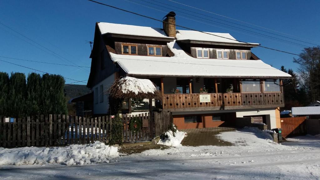 a house with a wooden fence in the snow at Apartmány Krásná - K68 in Jablonec nad Nisou
