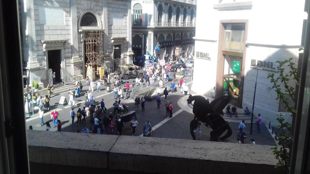 Una folla di persone che camminano per strada in una città di Toledo Street B&b a Napoli