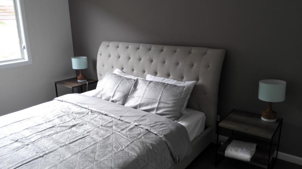 a bedroom with a white bed with two night stands at Dreamcatcher@Bicheno in Bicheno