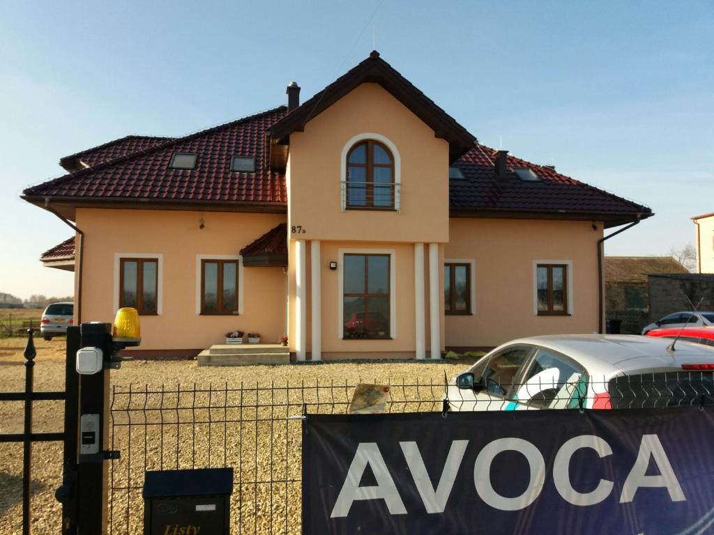 uma casa com um sinal em frente em Noclegi Avoca em Pyrzowice