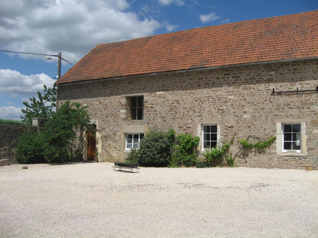 um edifício de tijolos com um banco à frente em Gite Le Village em Normier