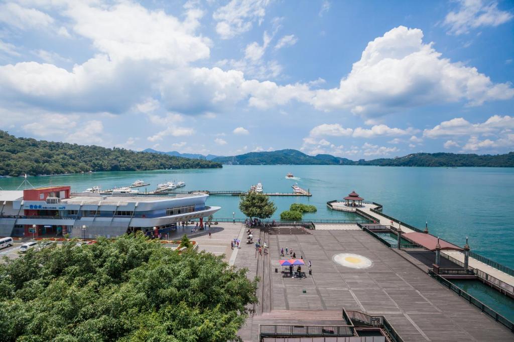 un quai sur un lac avec des bateaux dans l'eau dans l'établissement Shuian Lakeside Hotel, à Yuchi