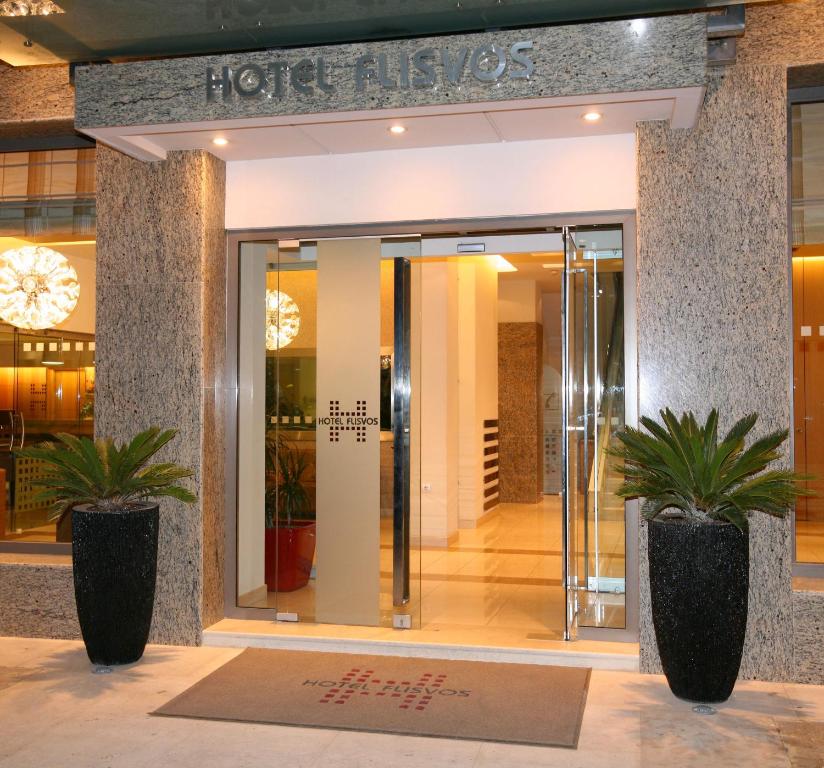 a hotel lobby with two potted plants in front of a door at Hotel Flisvos in Kalamata