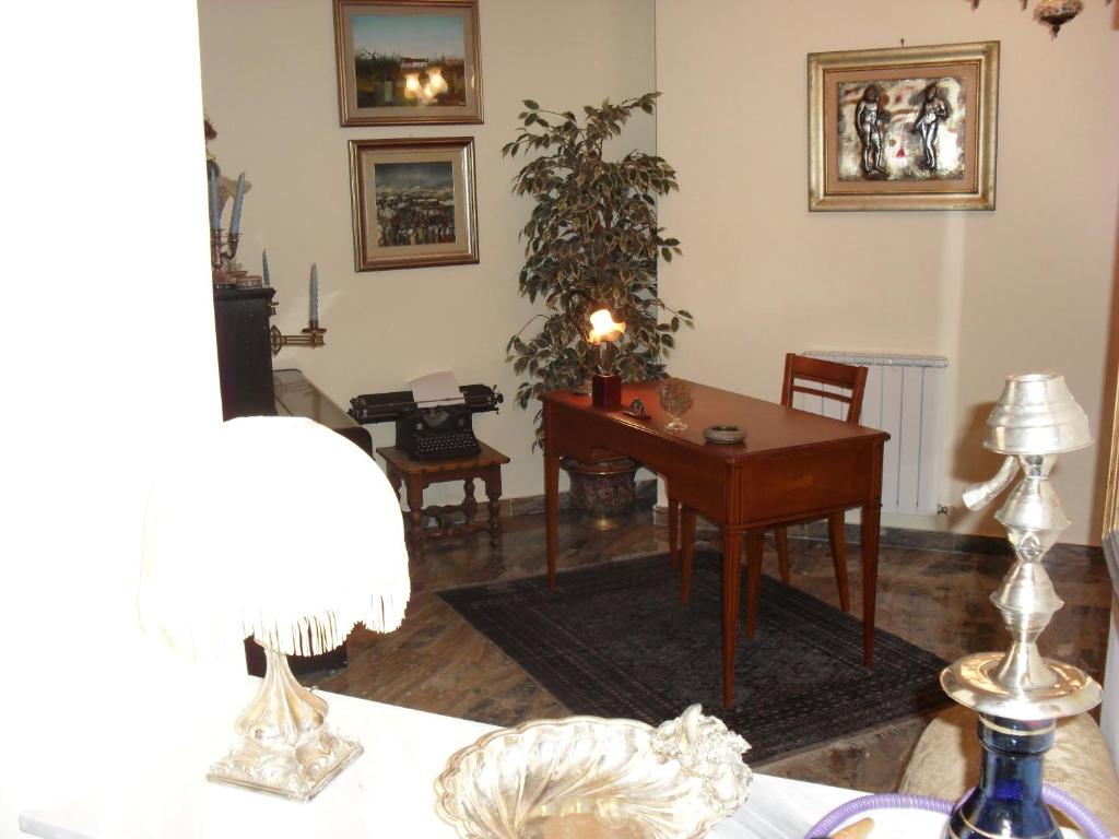 een woonkamer met een bureau en een tafel bij Agave in Reggio di Calabria
