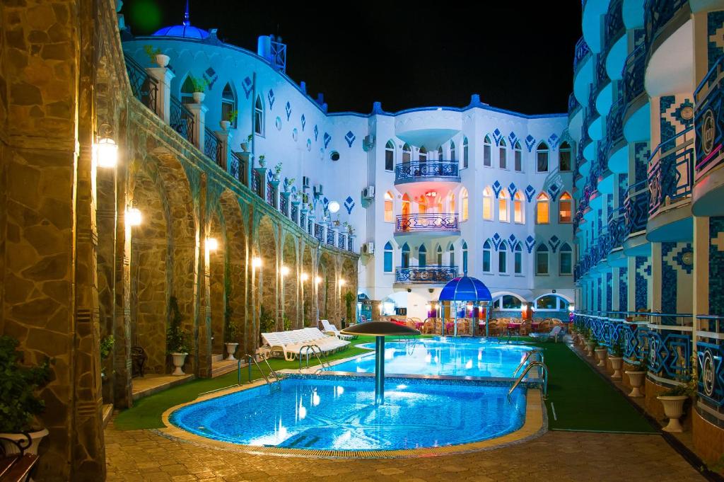 un gran edificio con piscina por la noche en 1001 Noch Hotel, en Koreiz