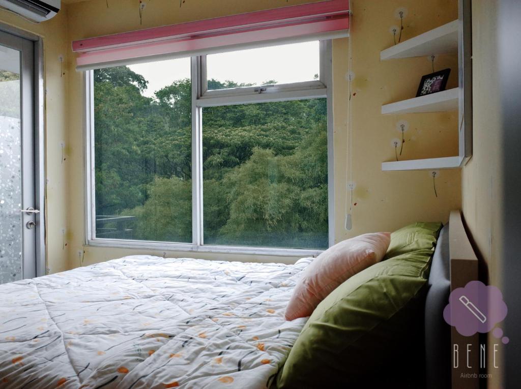 バンドンにあるBene Room at Jarrdin Cihampelasのベッドルーム1室(ベッド1台、大きな窓付)