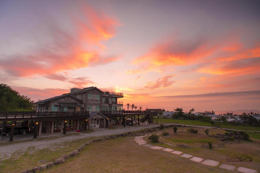 a large building with a sunset in the background at Fully One B&amp;B in Taitung City