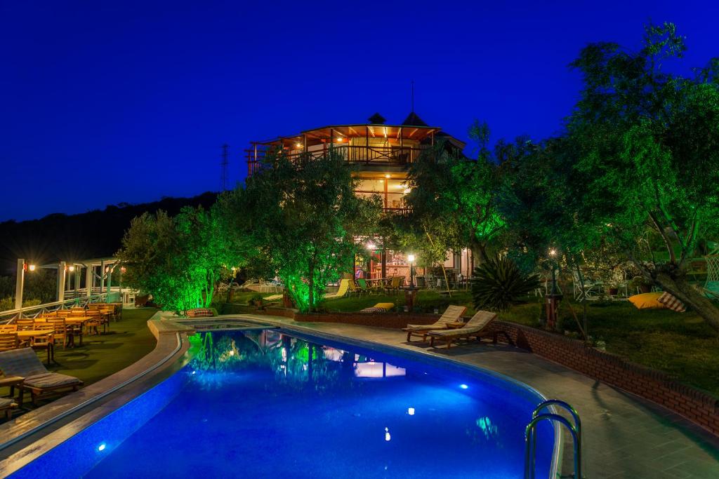 a house with a swimming pool at night at Aeneas Hotel in Altınoluk