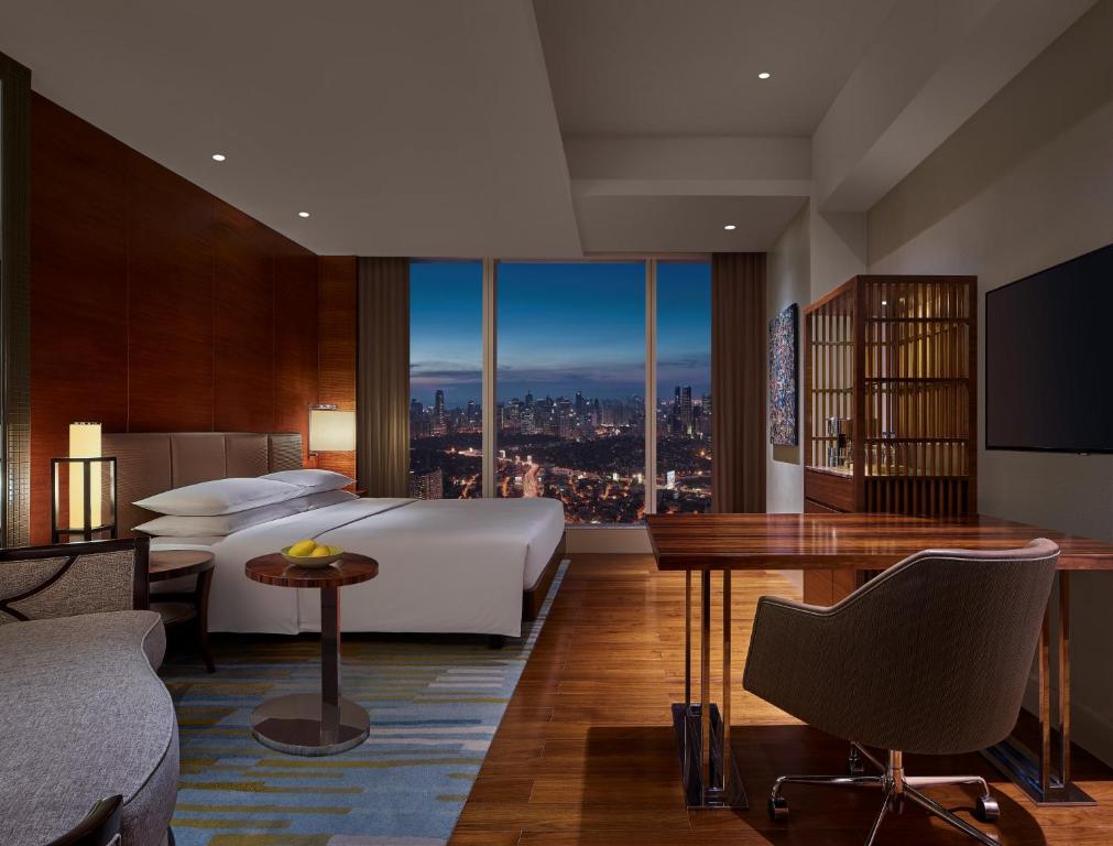 a hotel room with a bed and a view of a city at Grand Hyatt Manila in Manila