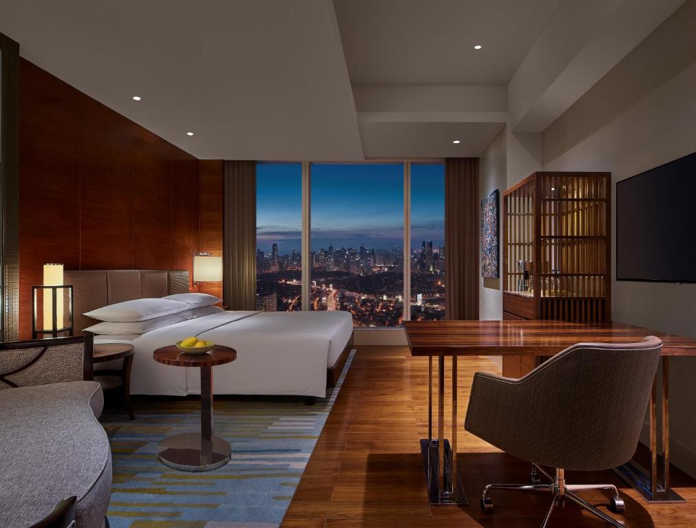 マニラにあるGrand Hyatt Manilaのベッドと街の景色が見えるホテルの部屋