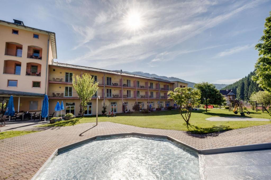 a resort with a swimming pool in front of a building at JUFA Hotel Veitsch in Veitsch