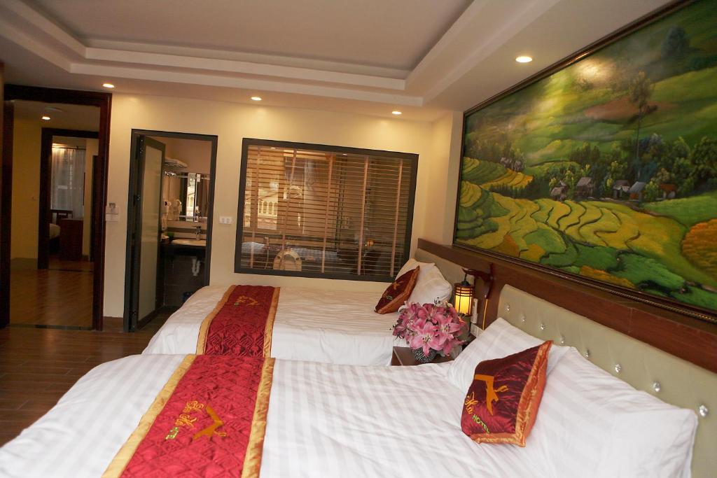 1 dormitorio con 2 camas y una gran pintura en la pared en Son Ha Sapa Hotel Plus en Sa Pa