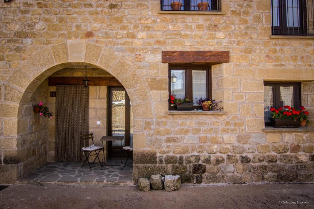 un ingresso a un edificio in pietra con due finestre di Apartamentos Turisticos Rio Gallego a Fontellas