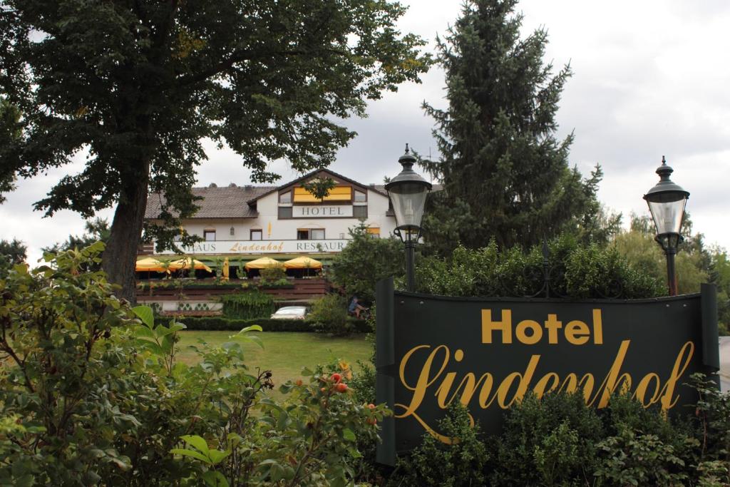 Hotel-Restaurant Lindenhof في Kreuzwertheim: وجود لافته حول الفندق امام مبنى