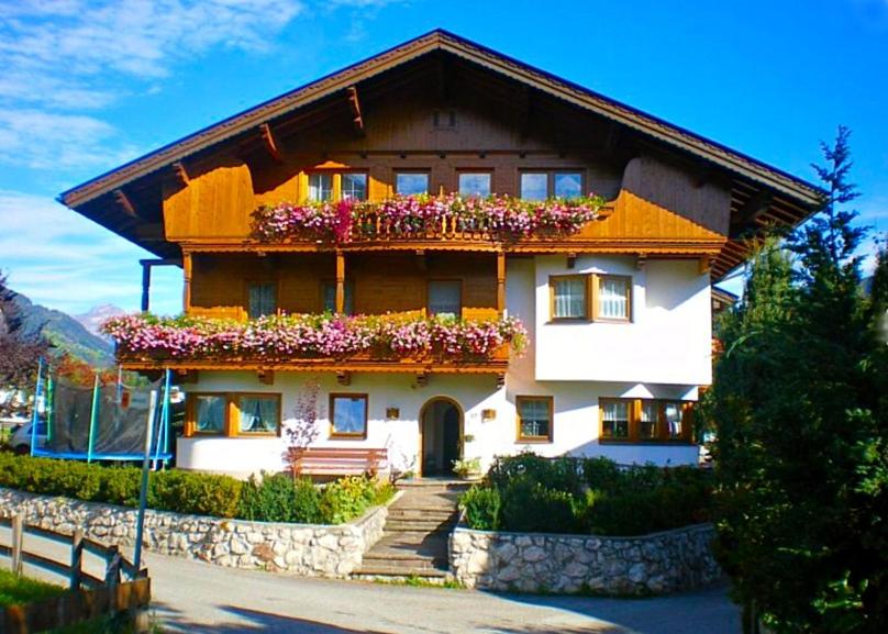 una casa con flores a un lado. en Ferienwohnungen Luxner, en Fügen