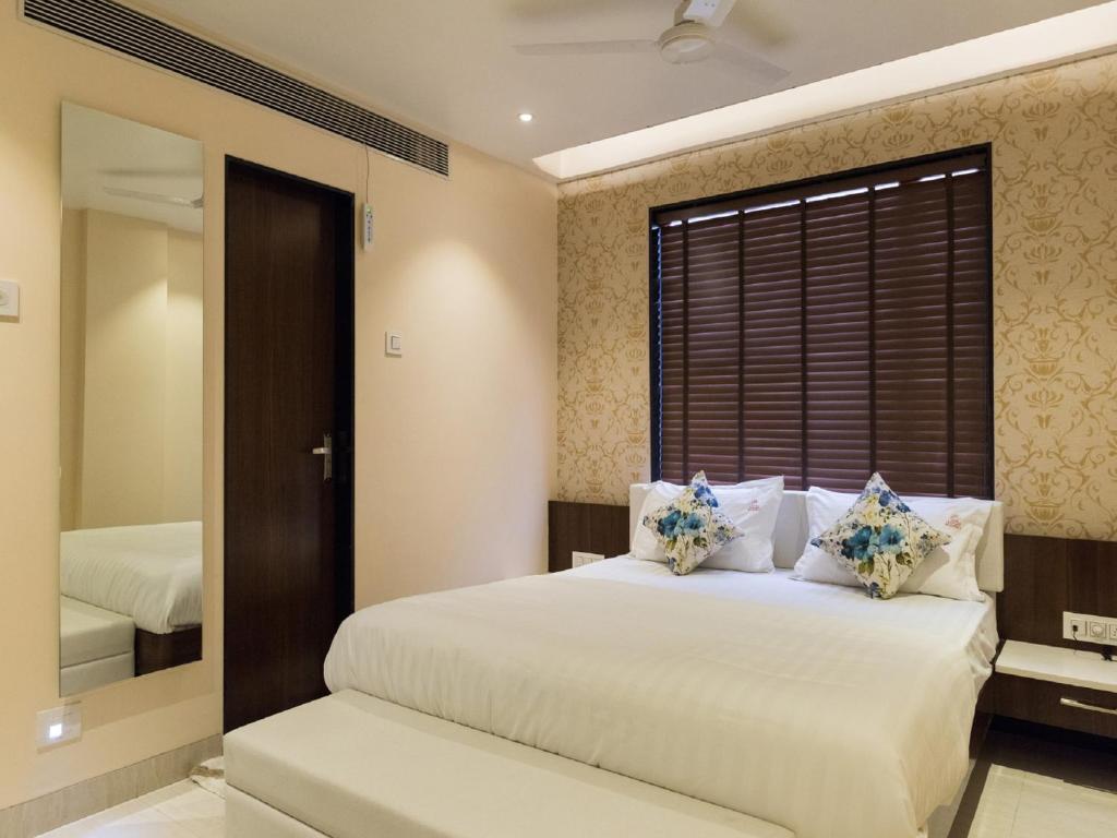 ein Schlafzimmer mit einem großen Bett und einem Spiegel in der Unterkunft Hotel Sangat Regency in Bhopal